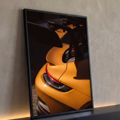 Traseira de carro esportivo laranja com aerofólio preto e lanterna vermelha em luz lateral, quadro decorativo