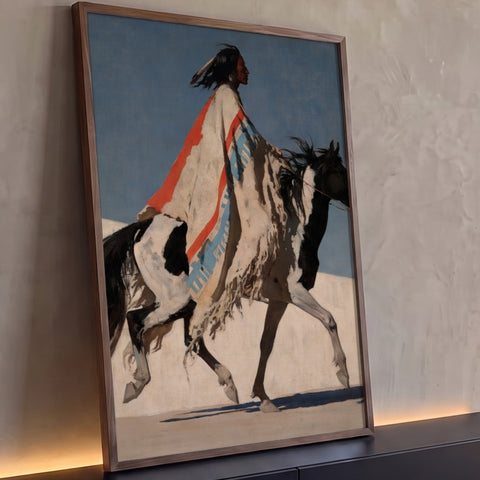 Indígena de perfil com manto listrado laranja e azul montado em cavalo malhado nas dunas, quadro decorativo