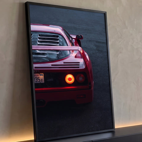Traseira de supercarro vermelho com lanternas acesas sobre asfalto ao anoitecer, quadro decorativo