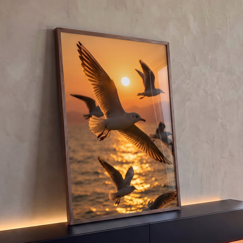 Gaivotas de asas abertas voando sobre o mar ao pôr do sol laranja com reflexo dourado, quadro decorativo