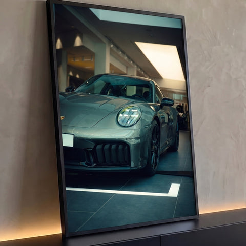 Porsche 911 cinza em showroom com farol aceso e rodas escuras, fotografia vertical, quadro decorativo