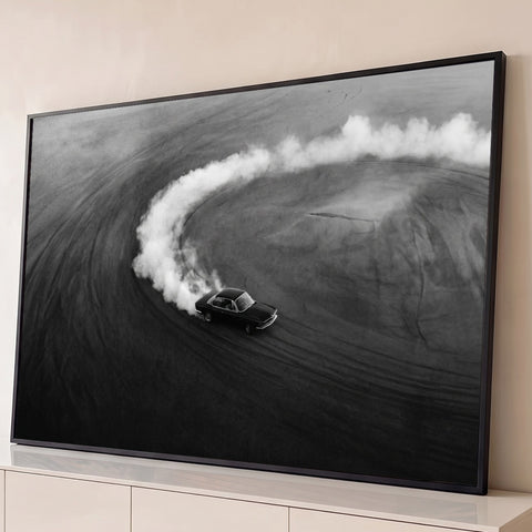 Carro antigo derrapando em círculo com fumaça branca, foto aérea preto e branco, quadro decorativo