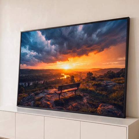 Pôr do sol laranja sobre vale com rio, banco de madeira no mirante e nuvens dramáticas, quadro decorativo