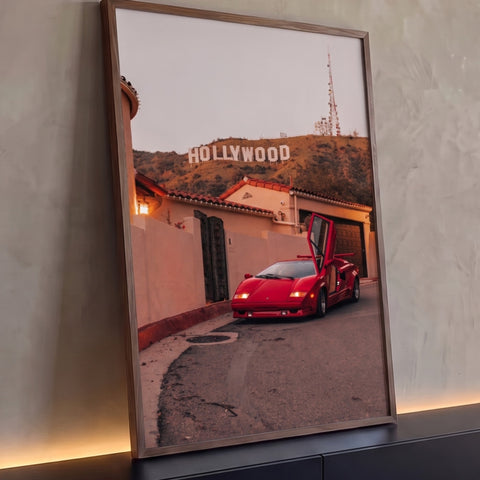 Carro esportivo vermelho de porta aberta em rua diante do letreiro Hollywood ao entardecer, quadro decorativo