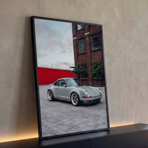 Quadro Decorativo Grande Carro Esportivo para Sala Cinza | quadros decorativos para sala | carro esportivo clássico cinza em rua de paralelepípedos com prédio de tijolos ao fundo | Porao dos Quadros