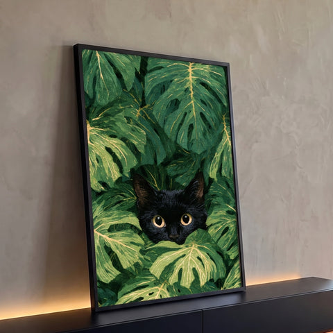 Gato preto de olhos dourados espiando entre folhas verdes de costela de adão, quadro decorativo