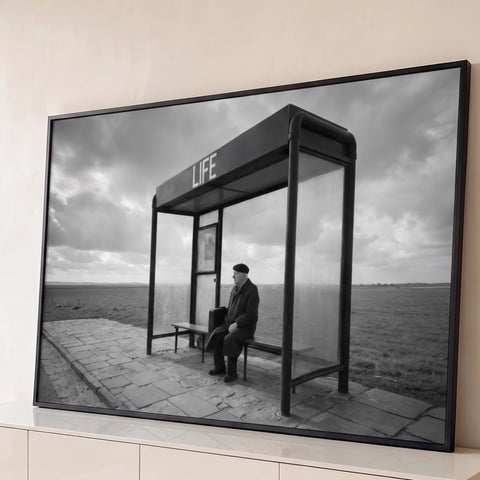Foto preto e branco de idoso de boina em ponto de ônibus escrito LIFE no campo, quadro decorativo