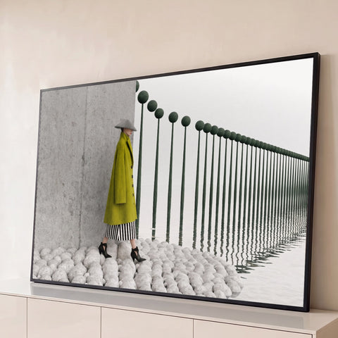 Mulher de casaco verde e chapéu cônico sobre pedras brancas ao lado de postes refletidos na água, quadro decorativo