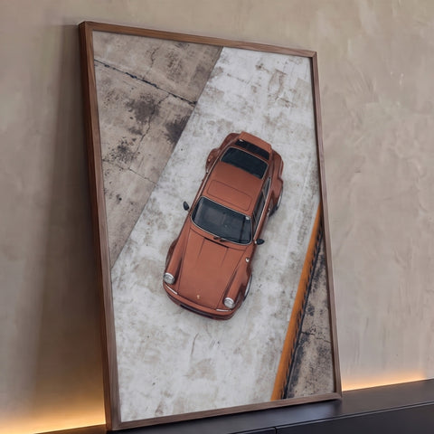 Porsche 911 clássico cor cobre fotografado de cima sobre piso de concreto cinza, quadro decorativo