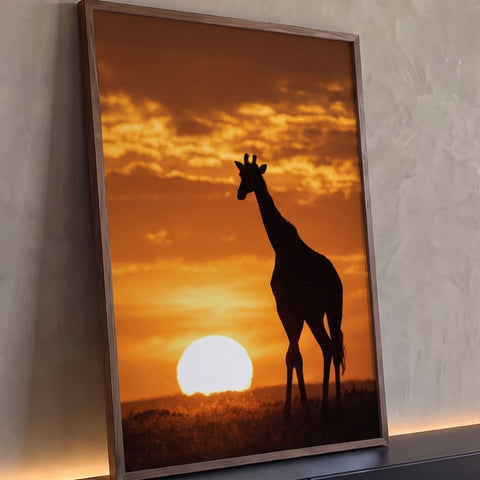 Girafa em silhueta na savana africana com sol se pondo no horizonte e céu laranja, quadro decorativo