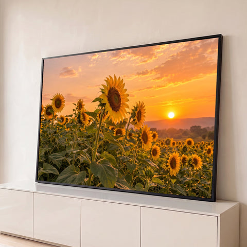 Campo de girassóis em primeiro plano com sol se pondo no horizonte e céu laranja, quadro decorativo