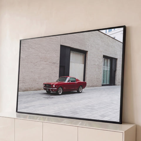 Mustang fastback vermelho clássico em frente a uma parede de tijolos bege em uma rua urbana, quadro decorativo