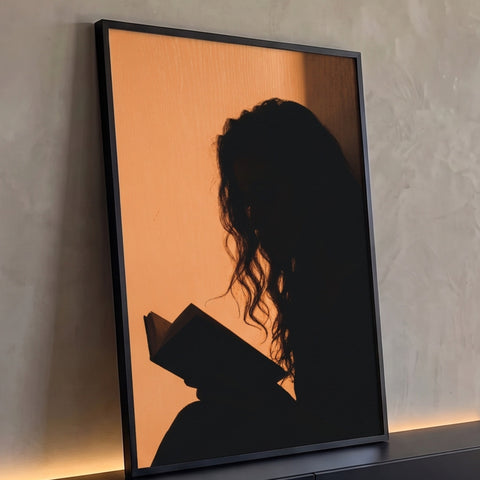 Silhueta de mulher de cabelo cacheado lendo livro contra parede laranja iluminada, quadro decorativo