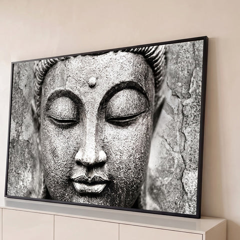 Rosto de Buda esculpido em pedra com olhos fechados e textura rachada em preto e branco, quadro decorativo
