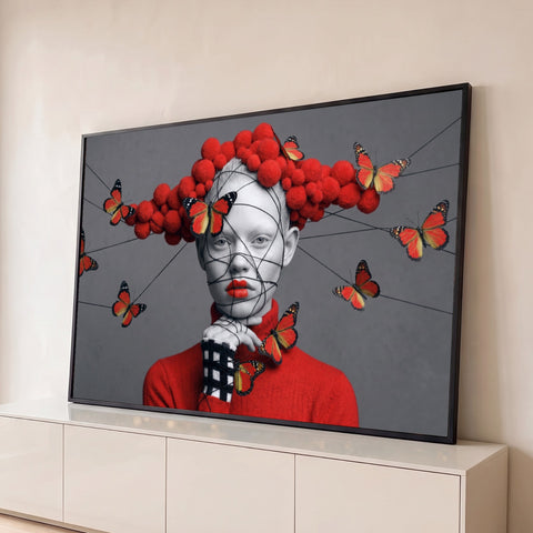 Mulher com rosto envolto em fios, lábios vermelhos, pompons e borboletas monarca sobre fundo cinza, quadro decorativo