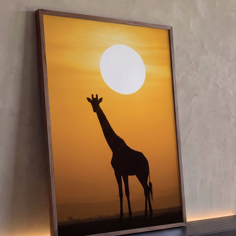 Silhueta de girafa na savana africana diante de sol enorme em céu laranja, quadro decorativo