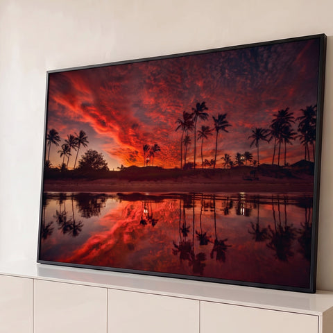 Pôr do sol tropical com palmeiras em silhueta e céu vermelho refletido na areia molhada, quadro decorativo