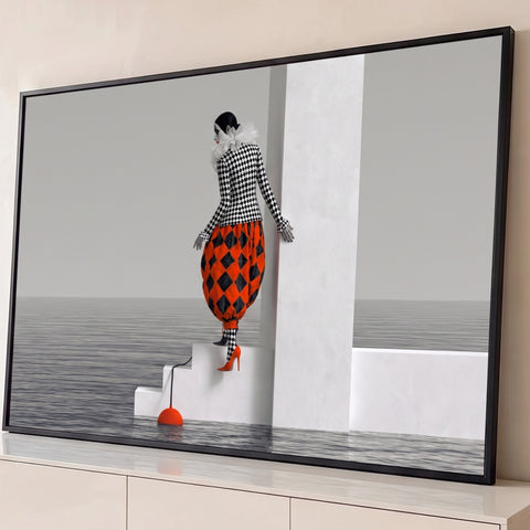 Arlequim em xadrez preto e laranja descendo uma escada branca sobre o mar cinza, quadro decorativo