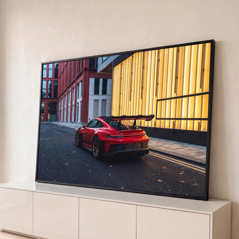 Porsche 911 GT3 vermelho com aerofólio e rodas douradas em rua urbana ao entardecer, quadro decorativo