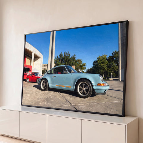 Porsche 911 clássico azul-claro com faixa laranja sob céu azul, efeito pintura a óleo, quadro decorativo