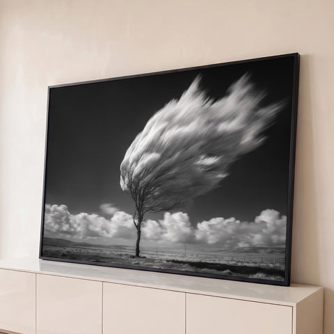 Árvore solitária com copa em movimento pelo vento, céu escuro e nuvens em preto e branco, quadro decorativo