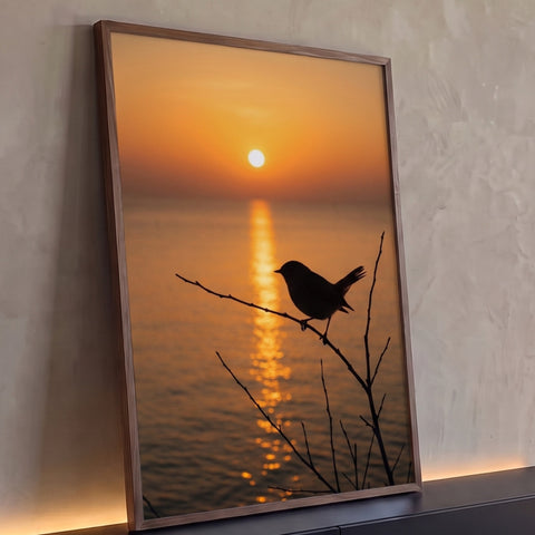 Pássaro em silhueta num galho seco diante do sol laranja refletido no mar, quadro decorativo