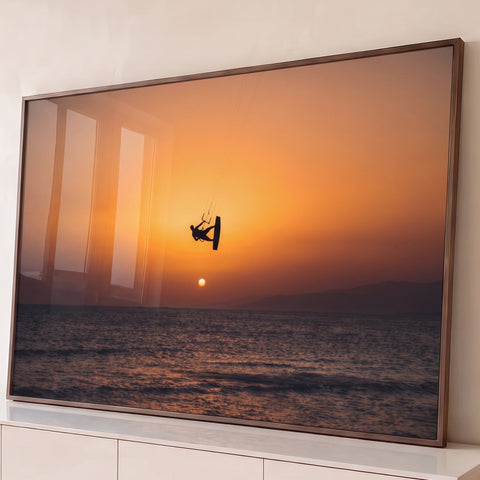 Silhueta de kitesurfista saltando no céu laranja do pôr do sol sobre o mar, quadro decorativo