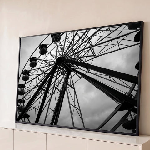 Fotografia preto e branco de roda gigante metálica vista de baixo contra céu nublado, quadro decorativo