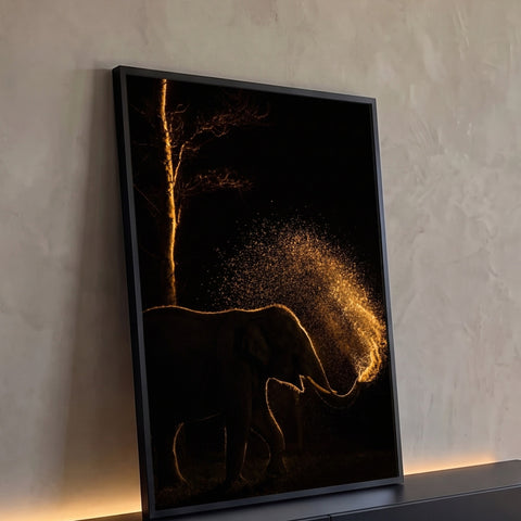Elefante em silhueta com contraluz dourado jogando água pela tromba sob árvore na noite, quadro decorativo
