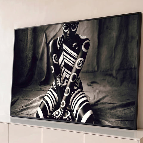 Mulher negra ajoelhada com corpo pintado em listras e círculos tribais brancos, foto P&B quadro decorativo