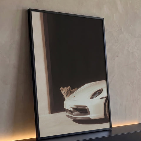 Quadro Decorativo Grande Filhote de Leão para Sala Preto | quadros decorativos para sala | filhote de leão espiando atrás de carro esportivo branco em vão escuro | Porao dos Quadros