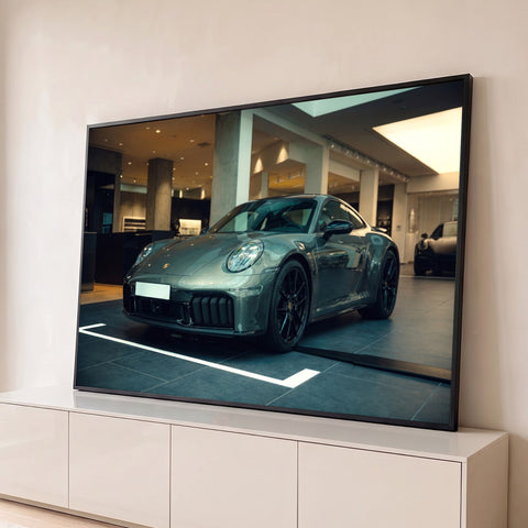 Porsche 911 cinza grafite com rodas pretas em showroom de concreto iluminado, quadro decorativo