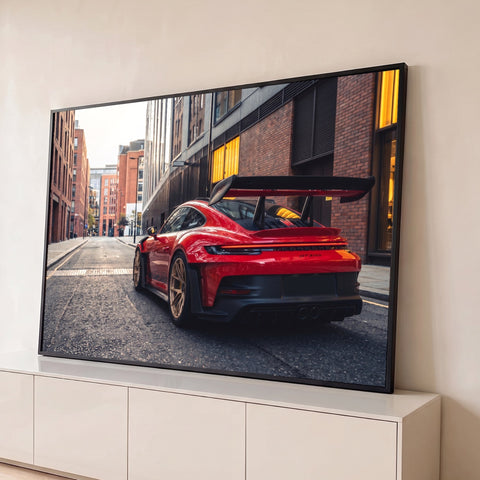 Porsche GT3 RS vermelho de traseira com aerofólio e rodas douradas em rua de tijolos, quadro decorativo