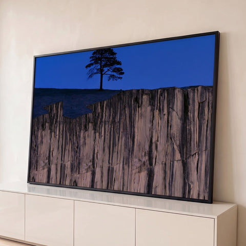 Árvore solitária em silhueta sobre rochedo de granito sob céu azul do anoitecer, quadro decorativo