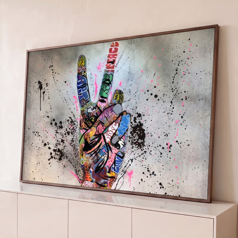 Mão fazendo sinal da paz coberta de grafite com respingos preto e rosa em fundo cinza, quadro decorativo