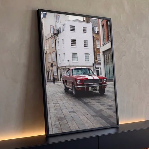 Mustang vermelho com listras brancas em rua de pedras e prédios brancos, quadro decorativo