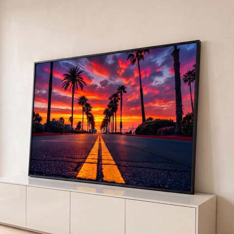 Estrada com faixa amarela e palmeiras em silhueta sob céu laranja e roxo ao pôr do sol, quadro decorativo