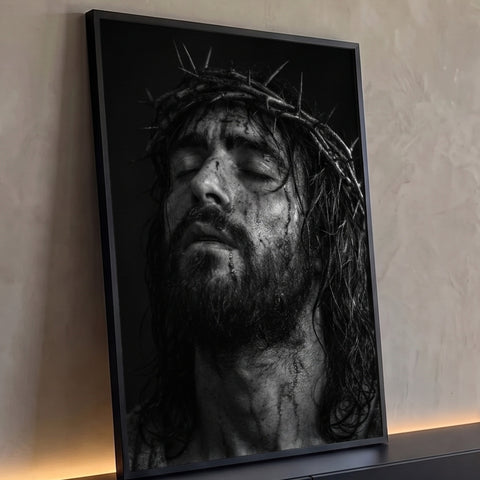 Jesus Cristo com coroa de espinhos, olhos fechados e rosto ferido em preto e branco, quadro decorativo
