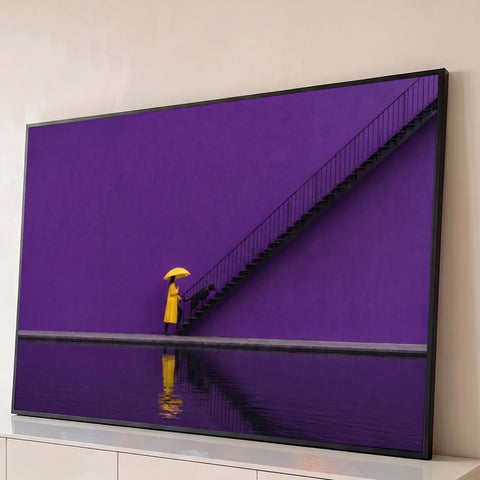 Mulher de guarda-chuva amarelo e cão preto subindo escada em parede roxa, quadro decorativo