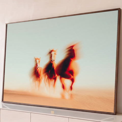Três cavalos alazões galopando de frente no deserto com efeito de borrão em tons bege, quadro decorativo