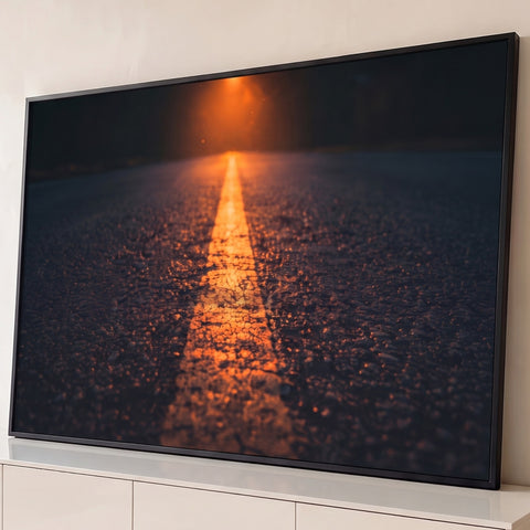 Estrada de asfalto à noite com faixa central iluminada por luz âmbar ao fundo, quadro decorativo