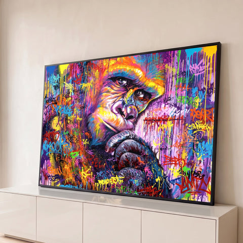 Gorila de mão no queixo pintado em grafite colorido sobre muro com pichações e respingos, quadro decorativo