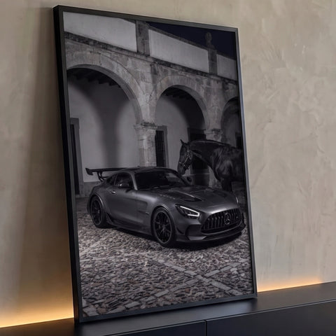 Carro esportivo cinza fosco ao lado de cavalo negro em pátio de pedra com arcos à noite, quadro decorativo