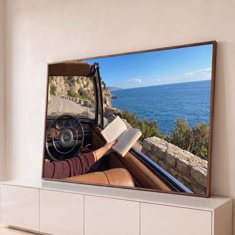 Interior de carro clássico conversível com livro aberto em estrada litorânea e mar azul, quadro decorativo