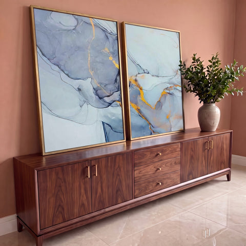 Quadro Decorativo Grande Abstrato Tinta para Sala Azul, díptico em duas telas com moldura dourada sobre aparador de madeira
