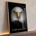 Águia de frente com olhos azuis em fundo preto e a palavra Liberdade dourada, quadro decorativo