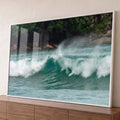 Onda do mar turquesa quebrando com espuma branca diante de rochas e mata verde na praia, quadro decorativo