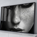 Close de rosto feminino com sardas, olhar sombreado e lábios em preto e branco, quadro decorativo