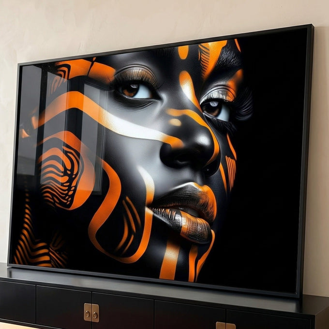 Rosto de mulher negra com pintura corporal em listras laranja e prata sobre fundo preto, quadro decorativo