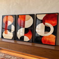Trio de telas com círculos e meias-luas laranja, vermelhas e bege sobre fundo preto, quadro decorativo